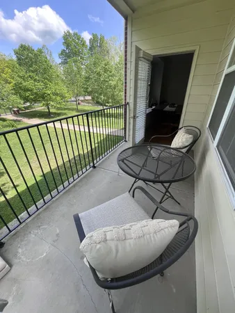 a living room with furniture and a floor to ceiling window