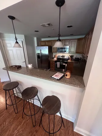 a kitchen with a table chairs and a wooden floor