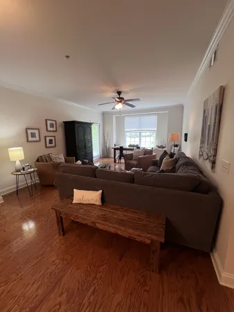 a living room with furniture and a wooden floor