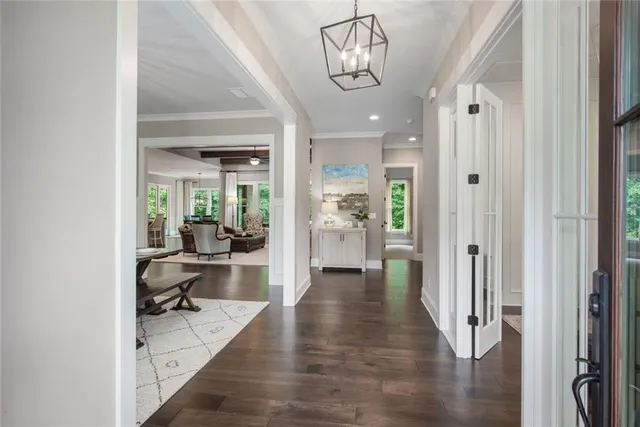 a kitchen with stainless steel appliances kitchen island granite countertop a dining table chairs and white cabinets