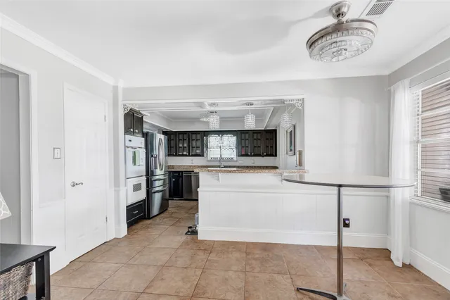 a kitchen with stainless steel appliances kitchen island granite countertop a refrigerator a stove and a sink