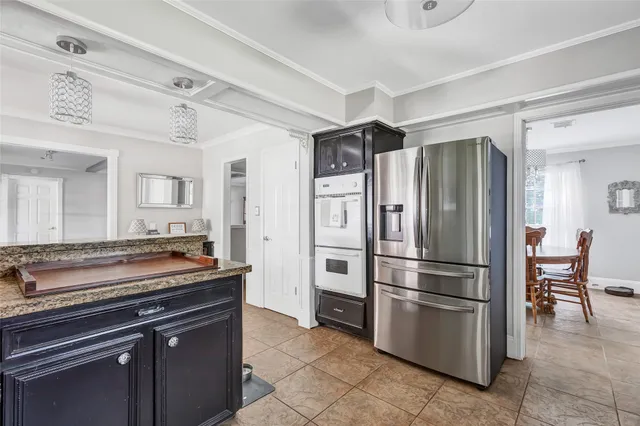 a kitchen with stainless steel appliances granite countertop a refrigerator and a stove