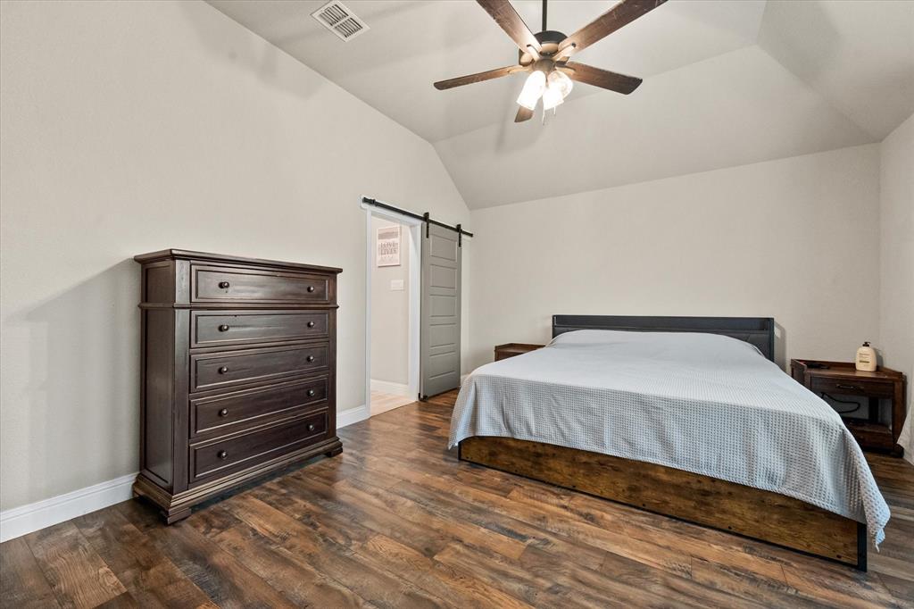 6365 Rhoden Avenue Godley, TX 76044 - Photo 16 of 31 a bedroom with a bed and a chandelier fan