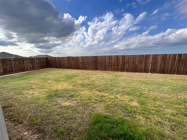 a view of yard with swimming pool and wooden fence