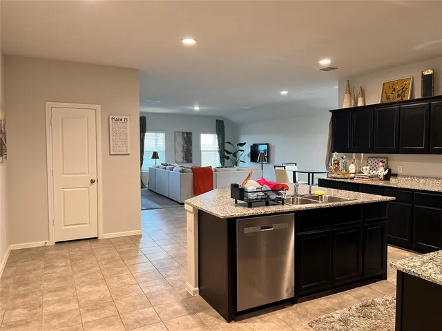 a kitchen with stainless steel appliances kitchen island granite countertop a refrigerator and a sink