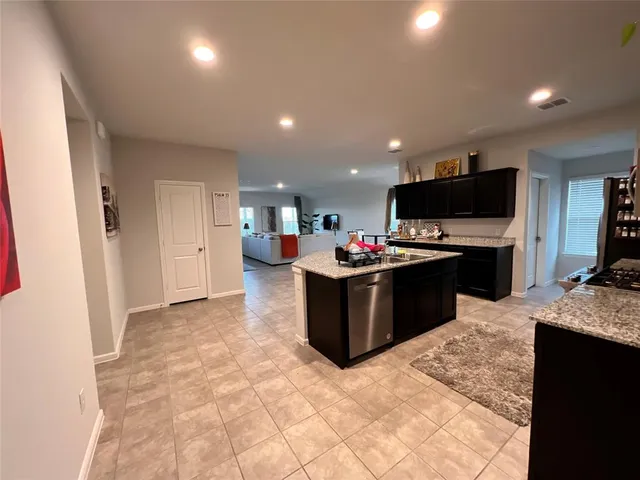 a kitchen with kitchen island granite countertop a sink and cabinets