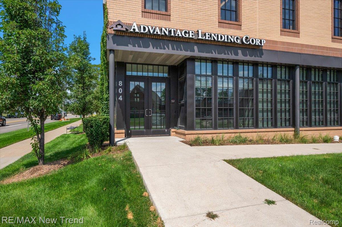 804 North Main Street, Unit 2H Rochester, MI 48307 - Photo 6 of 52 Brick facade building with large paned windows, prominent entry doors, and a concrete walkway