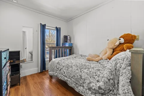 a bedroom with a bed and a flat tv screen on a dresser