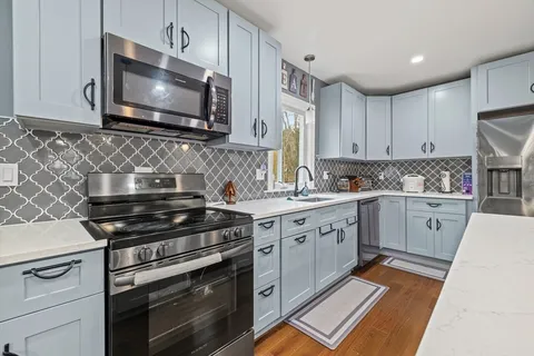 a kitchen with cabinets appliances and a sink