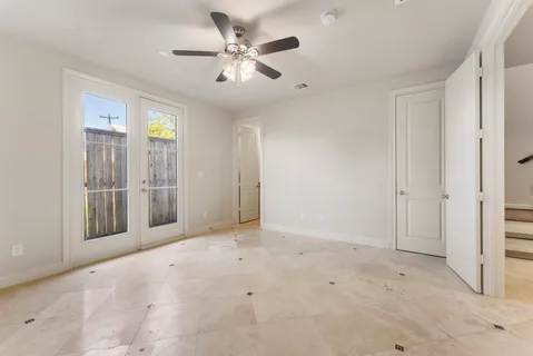 an empty room with fan and entrance