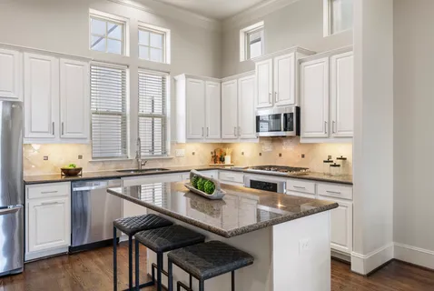 a kitchen with granite countertop a sink stove and cabinets