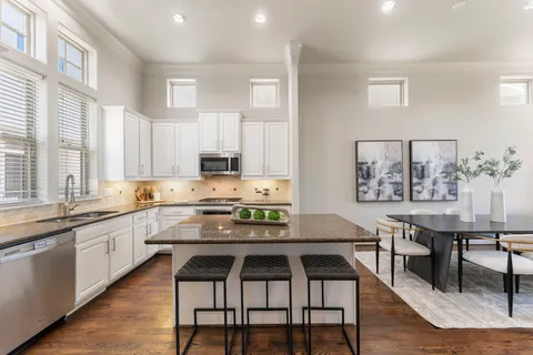 a kitchen with a table chairs stove and cabinets