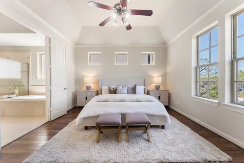 a spacious bedroom with a bed and a chandelier