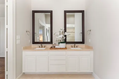 a bathroom with a tub a sink and a large mirror