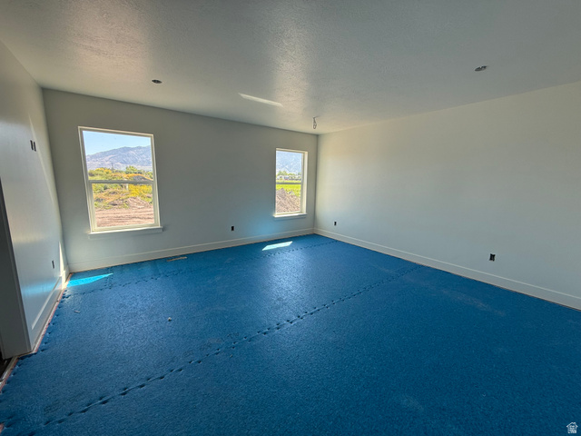 3308 South 1000 West Logan, UT 84321 - Photo 6 of 14 Spacious room featuring multiple windows, neutral wall tones, and ample natural light