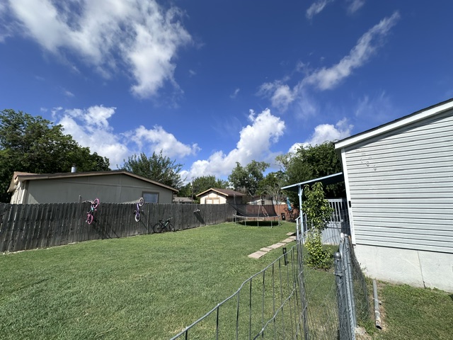 106 Ramirez Street Kyle, TX 78640 - Photo 19 of 19 A spacious yard perfect for recreation, enclosed by a sturdy wooden fence and featuring a covered patio.