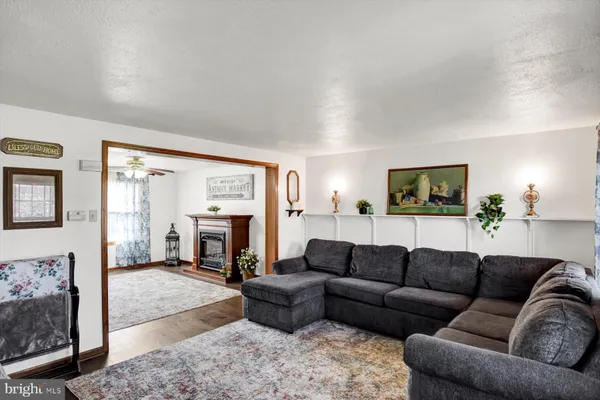 a living room with furniture a flat screen tv and a floor to ceiling window