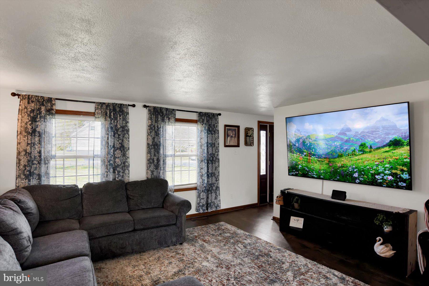 6 James Street Mill Hall, PA 17751 - Photo 13 of 39 a living room with furniture a flat screen tv and a floor to ceiling window
