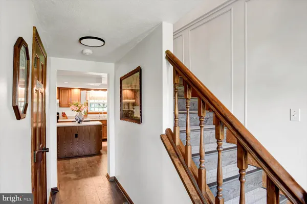 a view of a hallway with wooden chairs