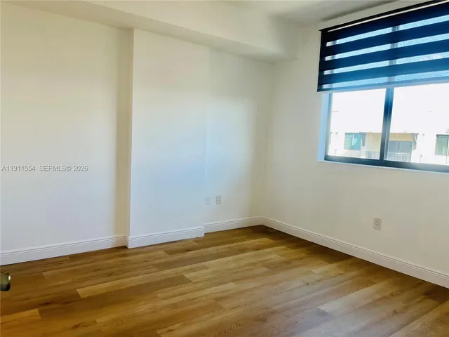 a view of a room with wooden floor and windows
