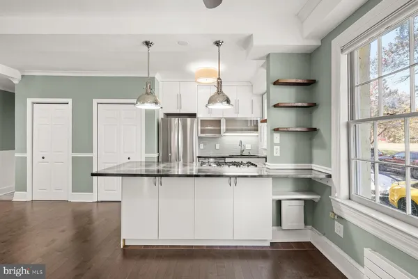 a kitchen with stainless steel appliances granite countertop a sink a stove and white cabinets