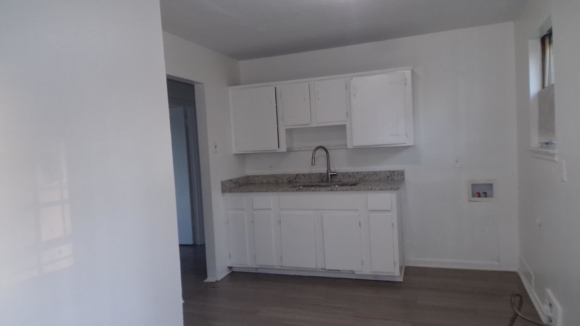 5057 Gill Road Memphis, TN 38109 - Photo 4 of 11 a kitchen with a sink dishwasher a stove and a refrigerator with wooden floor