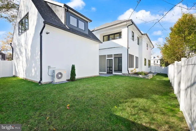 a view of a white house with a big yard and large trees