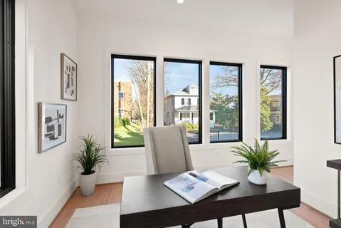 a view of an empty room with large window and wooden floor