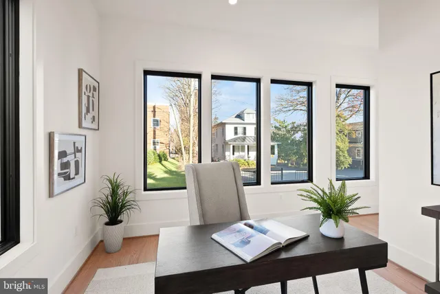 a view of an empty room with large window and wooden floor
