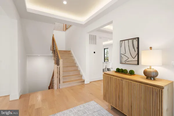 a view of a hallway with furniture and wooden floor