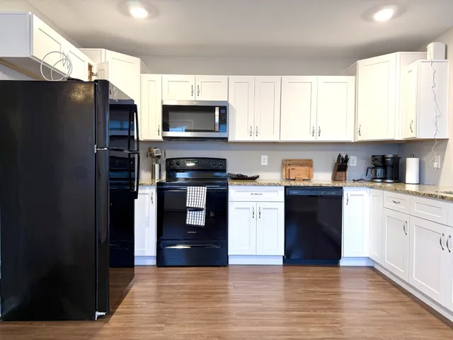 a kitchen with stainless steel appliances granite countertop a refrigerator and a stove top oven