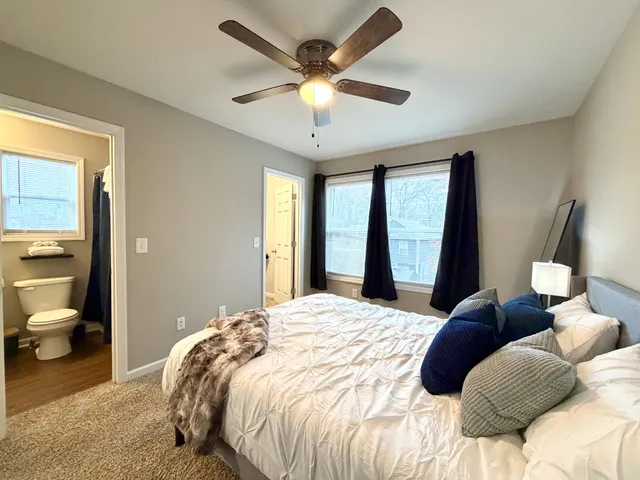 a bedroom with a large bed and a chandelier