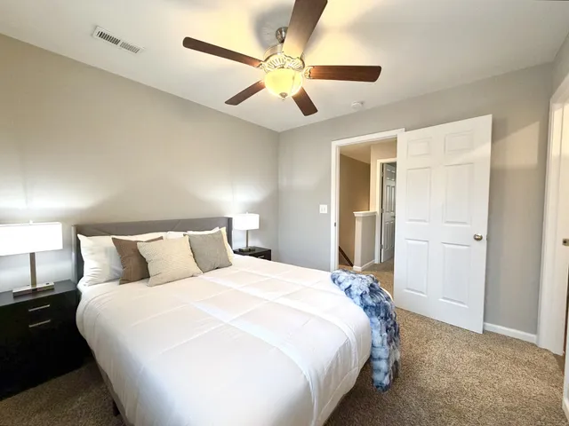 a bedroom with a bed and a ceiling fan