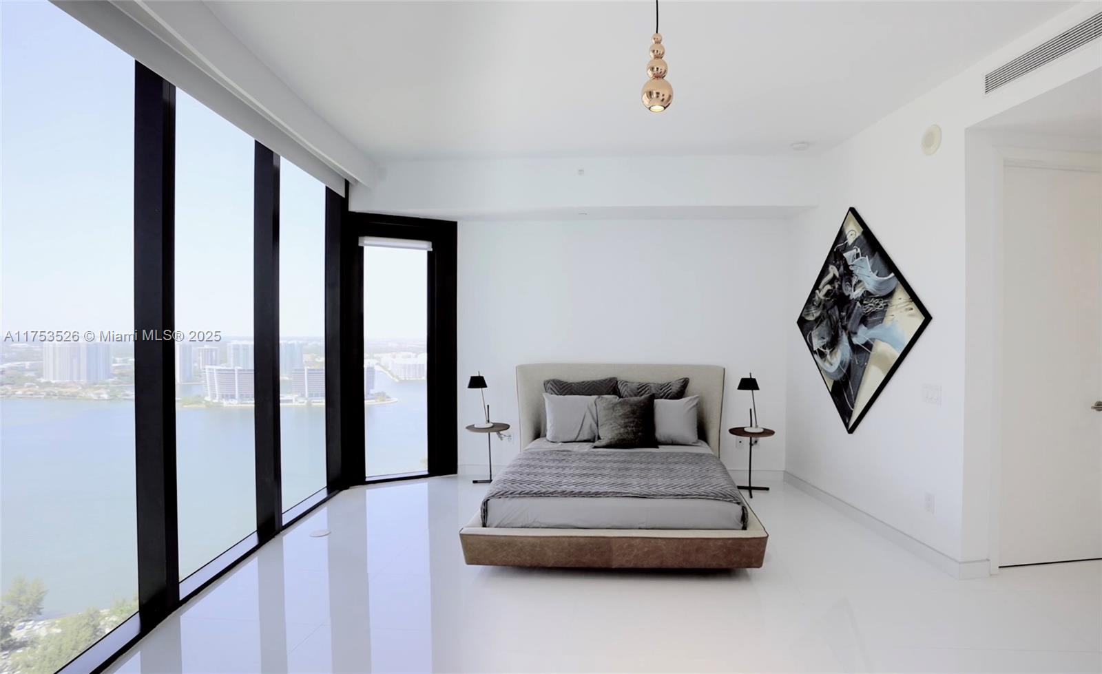 18555 Collins Avenue, Unit 3601 Sunny Isles Beach, FL 33160 - Photo 14 of 16 a bedroom with furniture and window