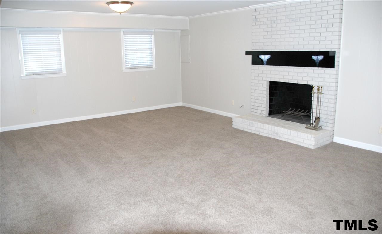 2701 Wycliff Road Raleigh, NC 27607 - Photo 10 of 16 Oversized den on lower level features a wood burning fireplace with brick hearth and a wetbar.