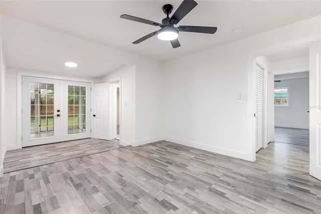 a view of an empty room with window and wooden floor
