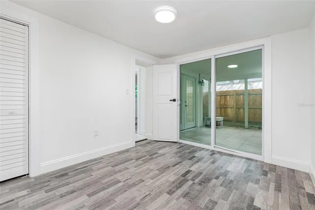 an empty room with wooden floor and sliding door