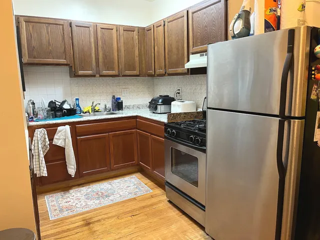 a kitchen with stainless steel appliances granite countertop a refrigerator sink and stove
