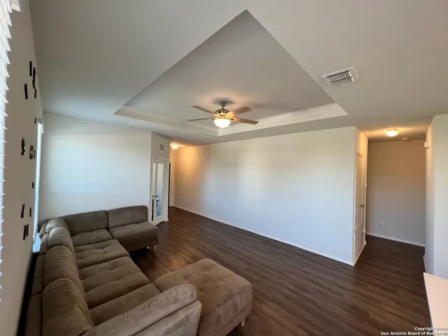 a kitchen with stainless steel appliances a sink dishwasher a refrigerator a stove and white cabinets with wooden floor