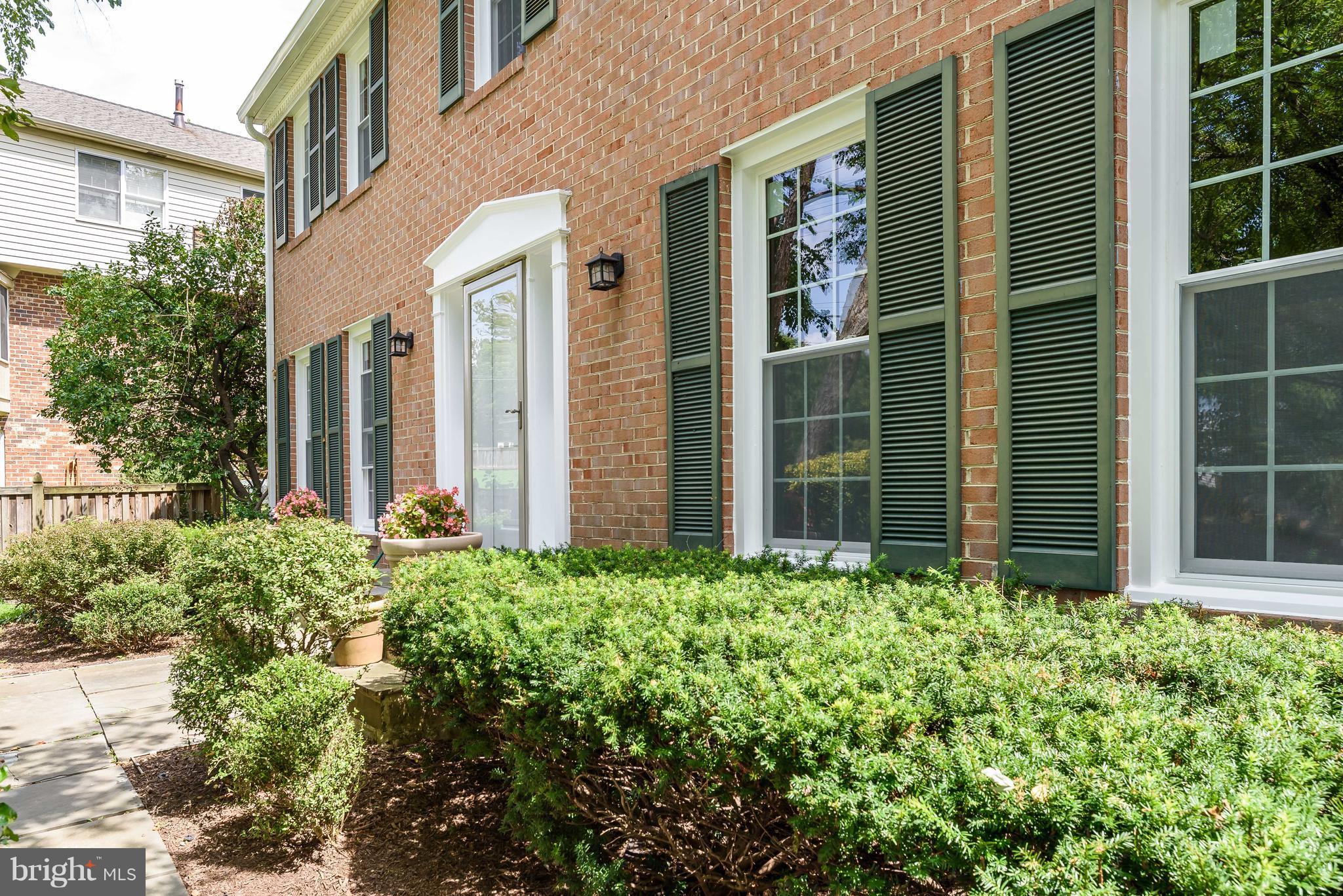 1709 Birch Road McLean, VA 22101 - Photo 2 of 30 front view of a brick house with a large window and potted plants