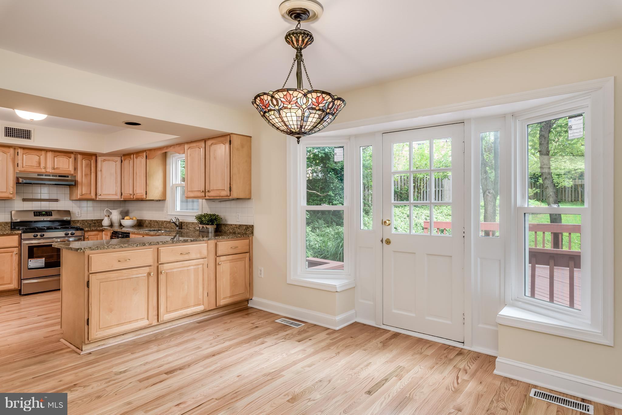 1709 Birch Road McLean, VA 22101 - Photo 15 of 30 a kitchen with stainless steel appliances granite countertop a stove a refrigerator a oven with white cabinets and wooden floor