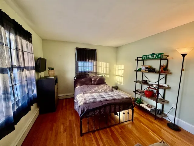 a bedroom with a bed and a flat tv screen on the dresser