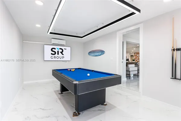 a room with pool table and paintings on the wall