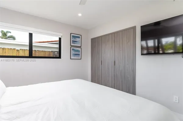 a bedroom with a large bed and a window