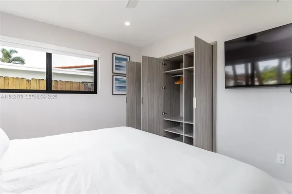 a bedroom with a bed and a large mirror