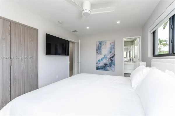 a bedroom with a bed and a flat screen tv