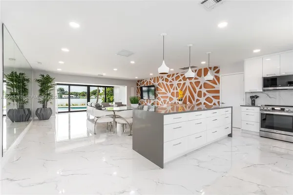 a kitchen with stainless steel appliances kitchen island granite countertop a stove a sink and a refrigerator