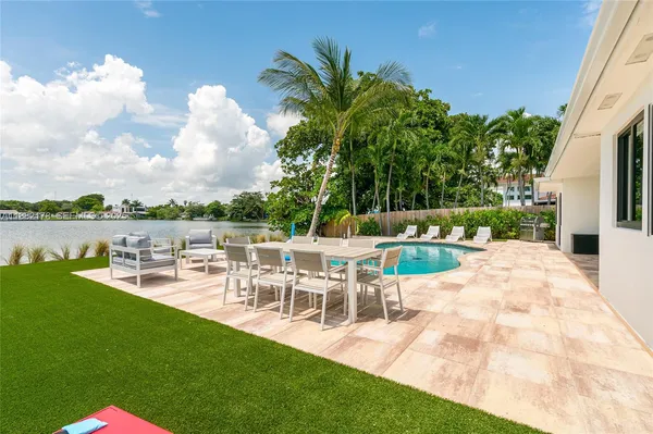 a swimming pool with outdoor seating and yard