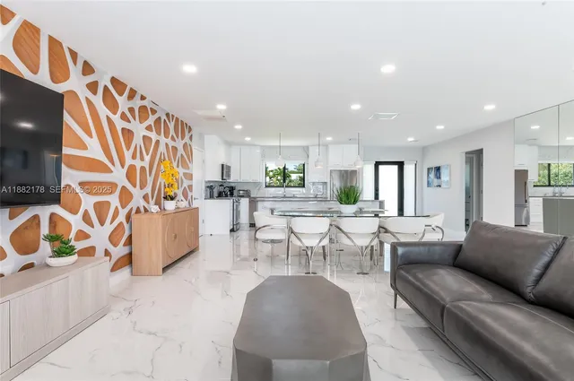 a living room with furniture and kitchen view