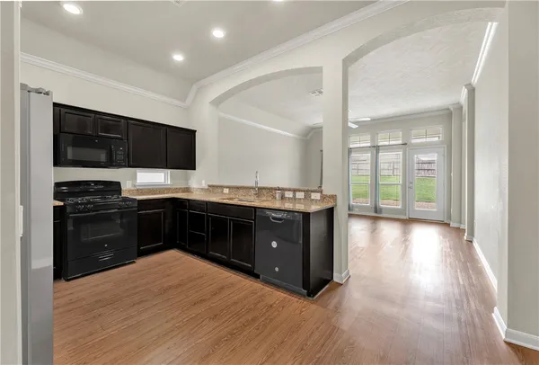 a kitchen with stainless steel appliances kitchen island granite countertop a stove a sink and a microwave